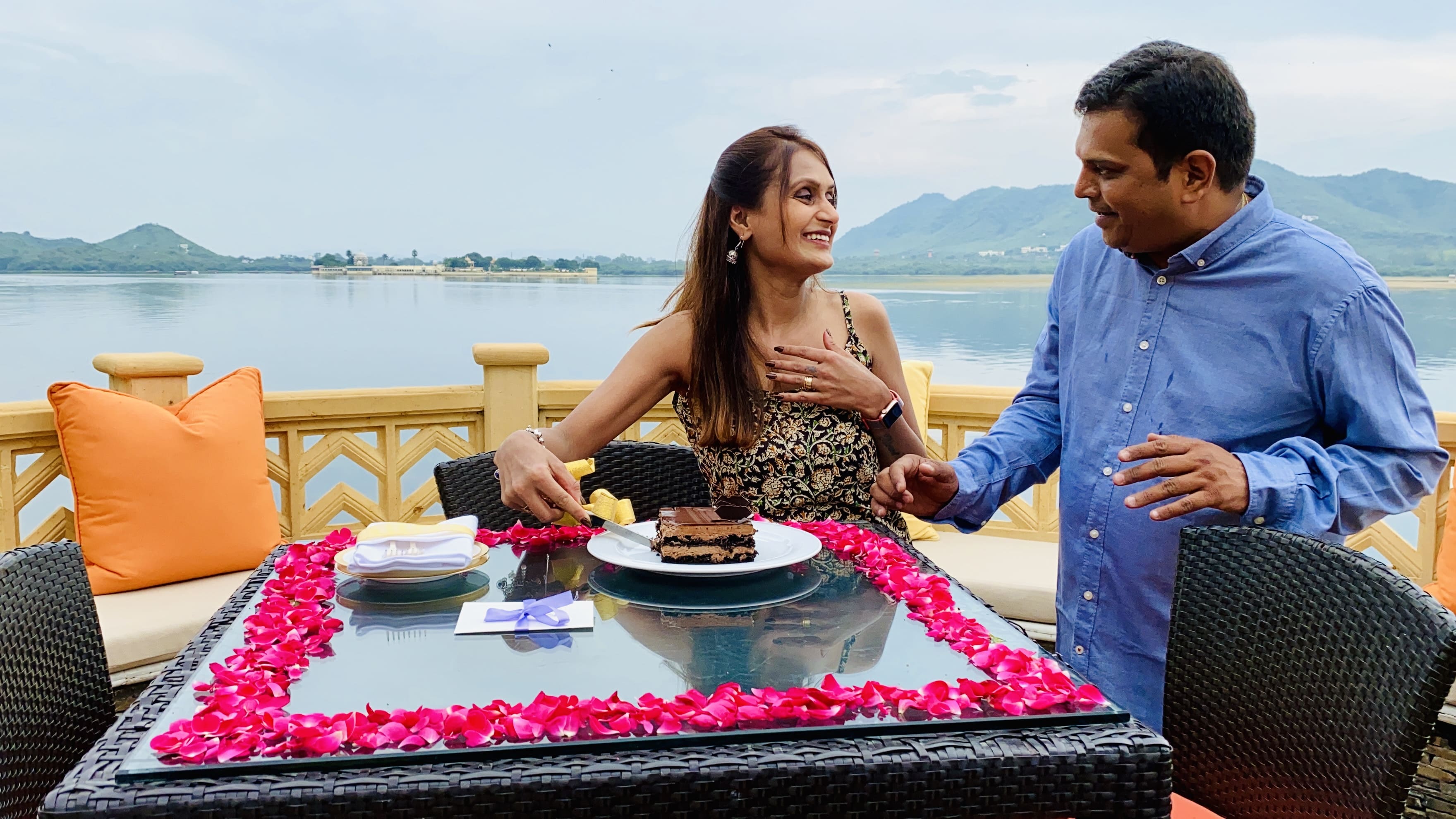 Cake cutting celebration at the leela palace udaipur with the backdrop of Lake pichola